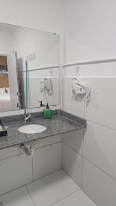 a bathroom with a sink and a mirror at Nobre Flats 201 in Petrolina