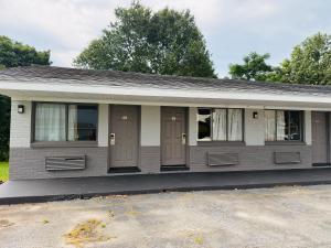 a small house with brown doors and windows at Sun N Sand Motel in Spartanburg