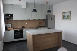 a kitchen with white cabinets and a stainless steel refrigerator at Wiki in Vodice