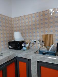 a kitchen counter with a sink and a microwave at Saceaas homes in Accra