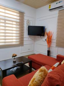 a living room with a red couch and a flat screen tv at Saceaas homes in Accra