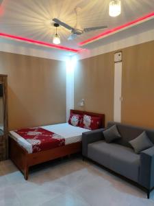 a room with a bed and a couch and red lights at Saceaas homes in Accra