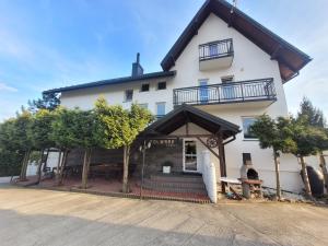 a large white building with trees in front of it at Bartpol Family & SPA in Gródek Nad Dunajcem