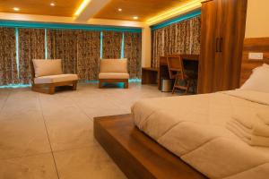 Un dormitorio con una cama y un escritorio y sillas. en Brookfield, en Pālampur