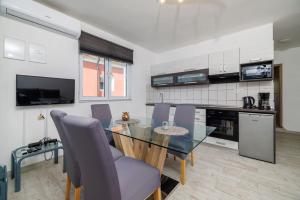 ein Esszimmer mit einem Glastisch und Stühlen in der Küche in der Unterkunft Apartments Toni in Banjol
