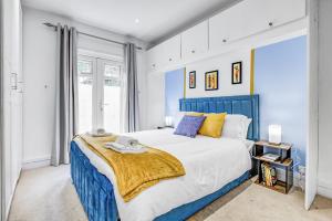 a blue and white bedroom with a large bed at Wimbledon 3Bath Sleeps7 AELTC in London