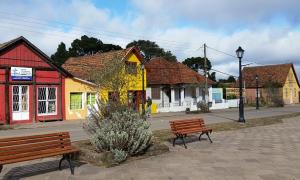 a group of benches in a town with buildings at Container 260 in Cambará