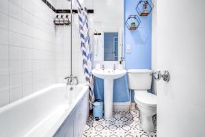 a bathroom with a tub sink and a toilet at Wimbledon 3Bath Sleeps7 AELTC in London +18 photos