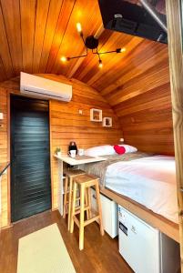 Zimmer mit einem Bett und einem Schreibtisch in einer Hütte in der Unterkunft Cabana com banheira em formato de barril in Curitiba