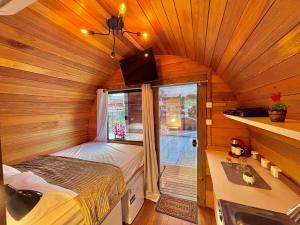 ein kleines Zimmer mit einem Bett und einem Fenster in der Unterkunft Cabana com banheira em formato de barril in Curitiba