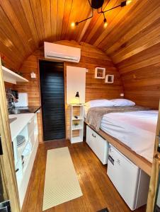 ein Schlafzimmer in einem winzigen Haus mit einem Bett darin in der Unterkunft Cabana com banheira em formato de barril in Curitiba