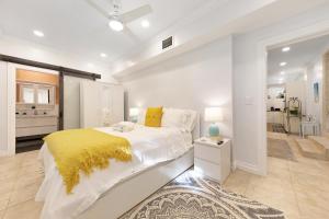 a white bedroom with a bed and a yellow blanket at Island Gardens Family Escape, Pool & Car included in Nassau +48 photos