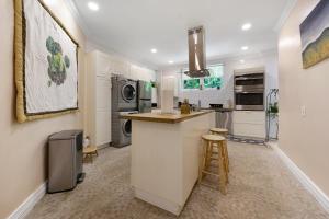 a kitchen with white cabinets and a counter with stools at DreamSpace Estate, Private Luxury Villa, Pool, Car and Beach in Nassau