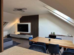 a living room with a table and a tv at Flex Apartments Blue in Mosonmagyaróvár