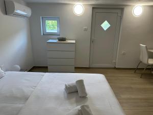 Un dormitorio con una cama blanca con dos toallas encima. en Apartma Tara, en Koper
