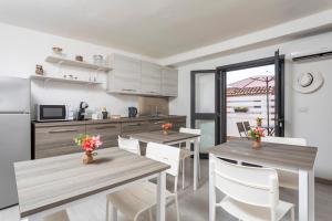 una cucina e una sala da pranzo con tavoli e sedie di Matrangela B&B Catania a Catania