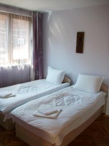 2 łóżka pojedyncze w pokoju z oknem w obiekcie Guest House Lilly w Nesebarze