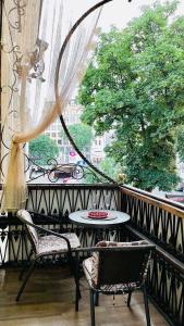 un balcon avec une table, des chaises et une fenêtre dans l'établissement Квартира с балконом в центре города, à Odessa