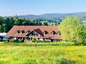 a large house with a roof on a field at Aotearoa - Mountain apartment in Bavaria, Mitterdorf - Mitterfirmiansreut in Mitterfirmiansreut