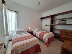 ein Zimmer mit zwei Betten in einem Zimmer mit Fenster in der Unterkunft Tortugas uno cero tres in Puerto Escondido + 14 Fotos