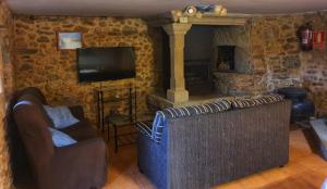 a living room with a couch and a fireplace at Casa do Campo in Viseo