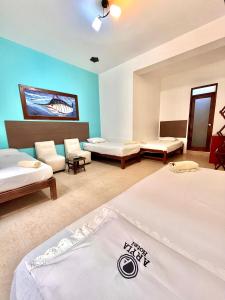 a hotel room with two beds and a couch at Aryia Máncora in Máncora +23 photos