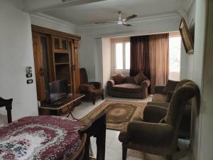 a living room with a couch chairs and a television at شارع العريش هرم in Banī Ghālib