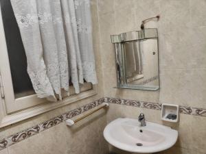 a bathroom with a sink and a mirror at شارع العريش هرم in Banī Ghālib