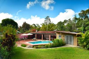 a house with a pool and a yard at Posada Casa del Sol in Caracas