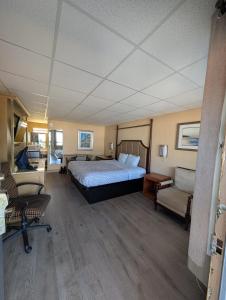 a bedroom with a bed and a couch and chairs at Express INN in Norfolk