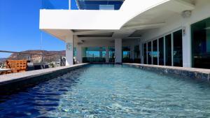 a swimming pool in front of a building at Hotel HBlue Malecón in La Paz
