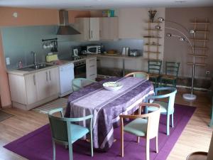 a kitchen with a table and chairs and a kitchen with a sink at Ferme renel in Poses