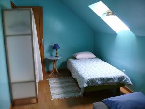 ein blaues Schlafzimmer mit einem Bett und einem Fenster in der Unterkunft Ferme renel in Poses