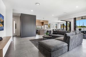una sala de estar con un sofá y una mesa en Luxe Capri Villa Heated Pool,10-min Walk to Beach, en Gold Coast