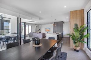 cocina y comedor con una gran mesa de madera en Luxe Capri Villa Heated Pool,10-min Walk to Beach, en Gold Coast 30 fotos más