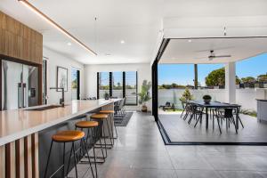cocina abierta y comedor con mesa y sillas en Luxe Capri Villa Heated Pool,10-min Walk to Beach, en Gold Coast