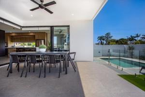 cocina abierta y comedor con mesa y sillas en Luxe Capri Villa Heated Pool,10-min Walk to Beach, en Gold Coast