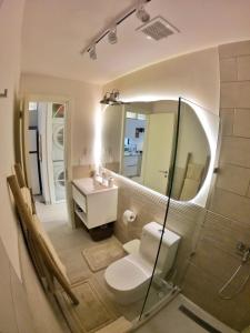 a bathroom with a toilet and a sink and a mirror at CASCO 114, king bed Stylish and Cozy apartment near Casco in Panama City