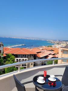 a table on a balcony with a view of the water at Ela, Kedar 5 in Sveti Vlas