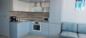 a kitchen with blue cabinets and a sink and a chair at Ela, Kedar 5 in Sveti Vlas