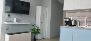 a kitchen with a tv on a wall at Ela, Kedar 5 in Sveti Vlas +3 photos