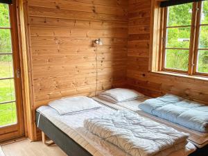 a bed in a wooden room with two windows at 8 person holiday home in Hadsund-By Traum in Odde