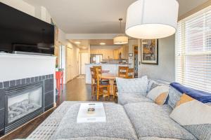 Una sala de estar con un sofá y una chimenea. en Condo Near Winter Park Resort and Steps From Shuttle, en Fraser