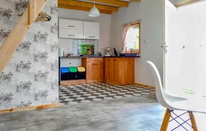 a kitchen with white cabinets and a checkered floor at Amazing Home In Ilawa With Wifi in Iława