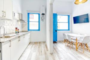 une cuisine avec des armoires blanches et une table et des chaises dans l'établissement Joros 1- Estupendo apartamento a 5 min a pie de la playa, à Santa Cruz de la Palma