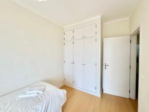 a white bedroom with a bed and a closet at Deluxe Oceanfront - Vue Sur la Mer in Peniche