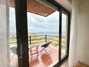 a balcony with a chair and a view of the ocean at Deluxe Oceanfront - Vue Sur la Mer in Peniche