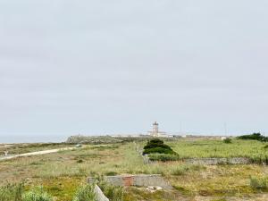 a view of a lighthouse on a grassy field at Deluxe Oceanfront - Vue Sur la Mer in Peniche