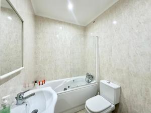 a bathroom with a tub and a toilet and a sink at Deluxe Oceanfront - Vue Sur la Mer in Peniche