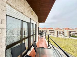 a balcony with chairs and a large window at Deluxe Oceanfront - Vue Sur la Mer in Peniche